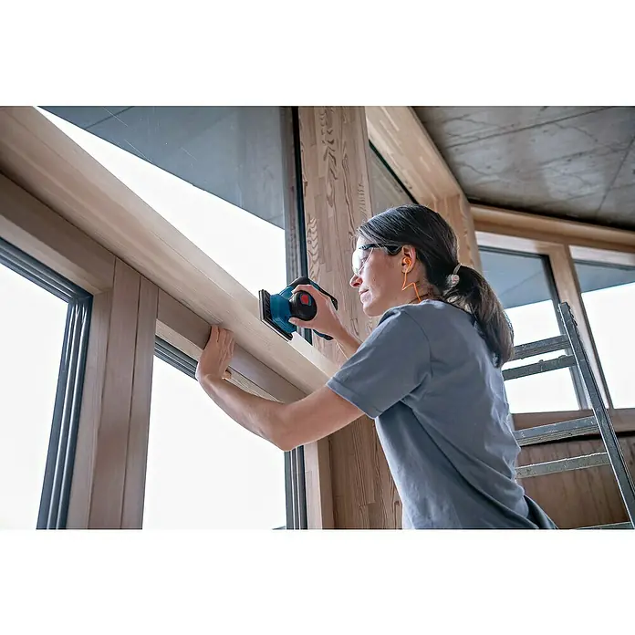Bosch Professional Akku-Schwingschleifer GSS 12V-13 PRO SOL - Ohne Akku, Leerlaufschwingzahl: 12.000 U/min - 20.000 U/min, 12 V - Frau schleift einen Holzfensterrahmen mit einem blau-schwarzen Schwingschleifer.