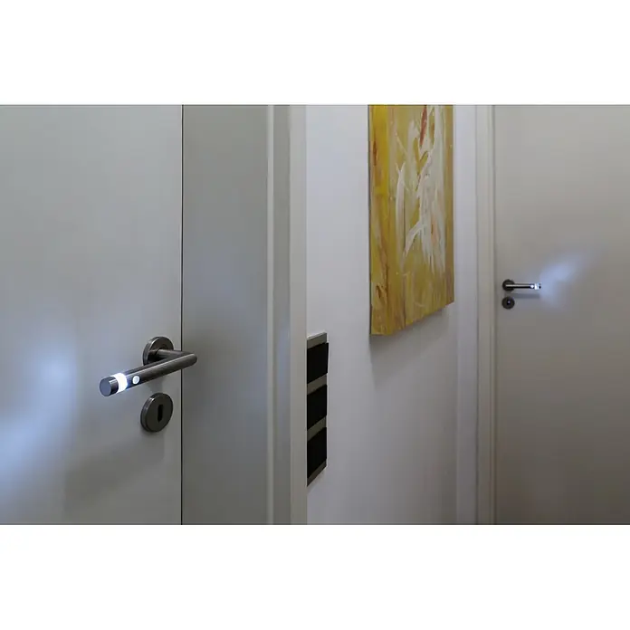 Diamond Doors Modern LED-Zimmertürgarnitur L-Form BB - Buntbart, Matt, Links/Rechts - Nahaufnahme von beleuchteten Türgriffen an weißen Türen mit moderner Kunst im Hintergrund. Intelligente Beleuchtung für modernes Wohnen.