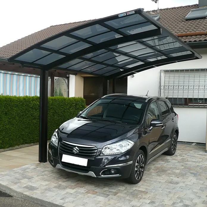 Ximax Carport Portoforte 60 - Außenmaß inkl. Dachüberstand (B x T): 2,7 x 4,95 m, Einzelcarport, Mattbraun, Schneelast: 75 kg/m² - Ein schwarzer Suzuki parkt unter einem modernen Carport mit dunklem Rahmen und transparentem Dach, der Schutz vor Witterungseinflüssen bietet.