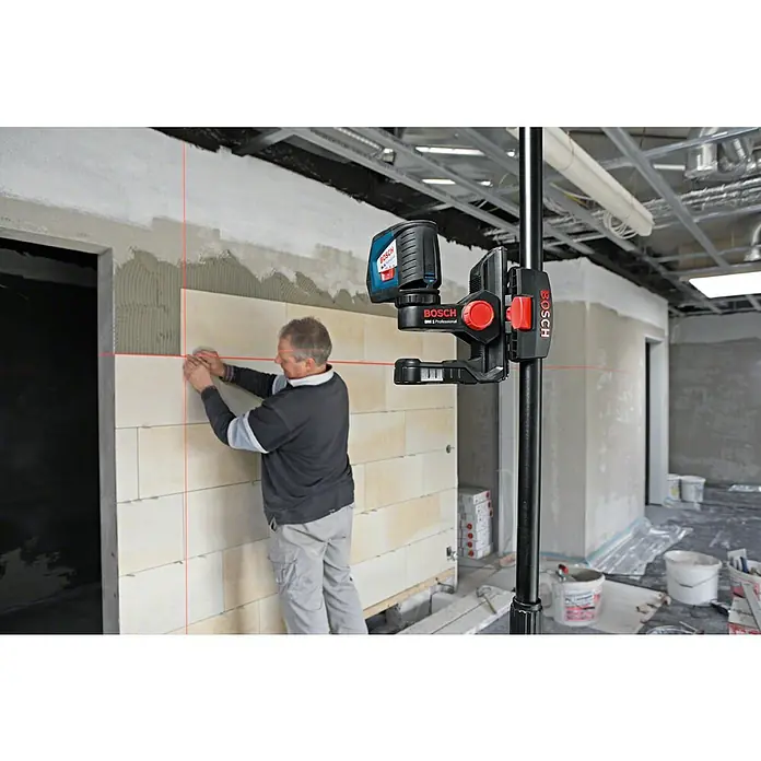 Bosch Professional Teleskopstange BT 350 - 140 cm - 350 cm - Bosch Laser-Nivelliergerät an Stange, projiziert rote Linien für Fliesenarbeiten eines Arbeiters.
