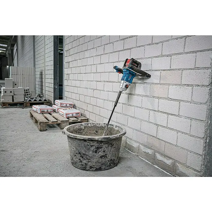 Bosch Professional Akku-Rührwerk GRW 18V- 160 PRO SOLO - 18 V, Anzahl Akkus: Ohne Akku - Ein blau-schwarzer Bosch Rührwerk mit Paddel taucht in einen Eimer mit gemischtem Material auf einer Baustelle, neben Mörtelsäcken.
