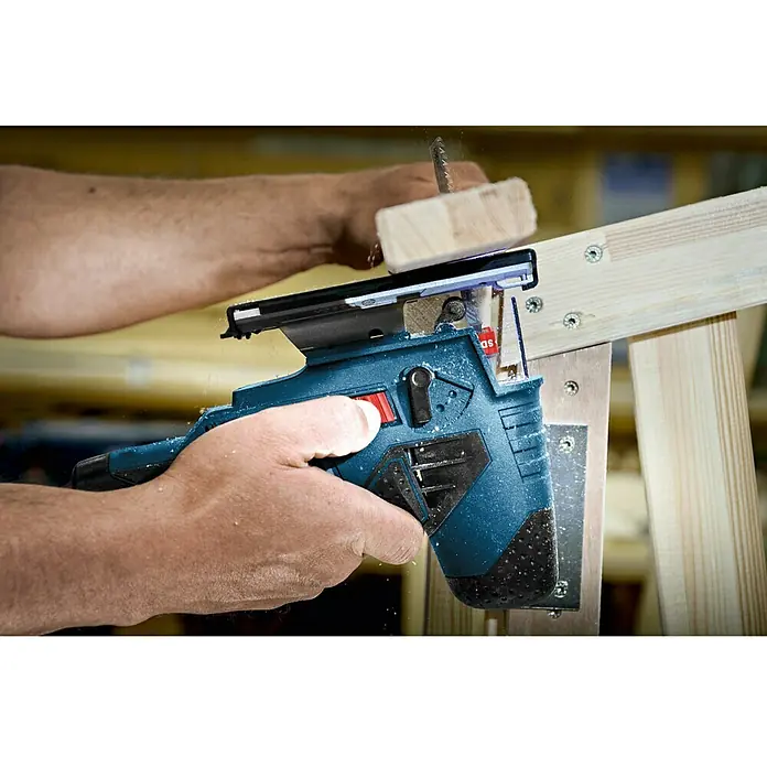 Bosch Professional Akku-Stichsäge GST 12V-7012 V, Li-Ionen, Ohne Akku, Leerlaufhubzahl: 1.500 /min - 2.800 /min - Nahaufnahme einer Stichsäge beim Schneiden von Holz, Fokus auf die Präzision des Werkzeugs.