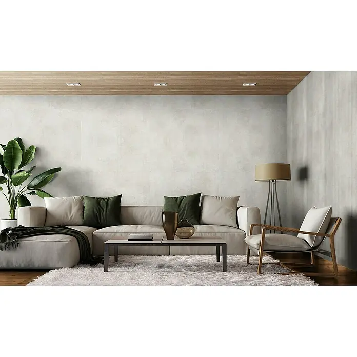 Revêt Wandpaneel SPC Wall - 1.200 x 600 mm, Beige - Ein modernes Wohnzimmer mit einem großen hellbeigen Ecksofa, grünen Kissen, einem Couchtisch, einem flauschigen Teppich und einem Holzstuhl.