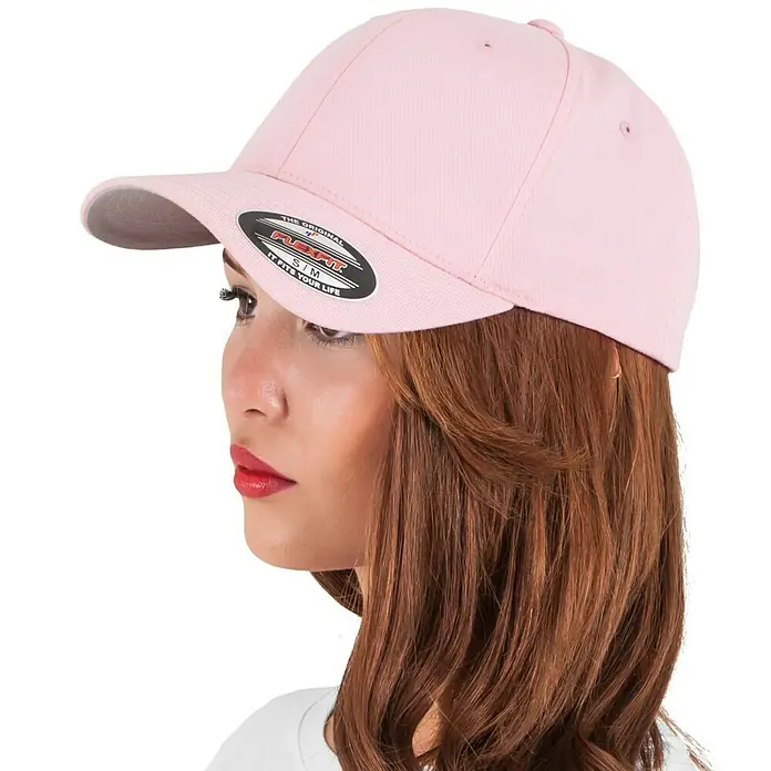Flexfit Gorra Wooly Combed - Rosa, S/M - Primer plano de una gorra Flexfit rosa en un modelo, destacando el diseño elegante y el ajuste cómodo de la gorra.