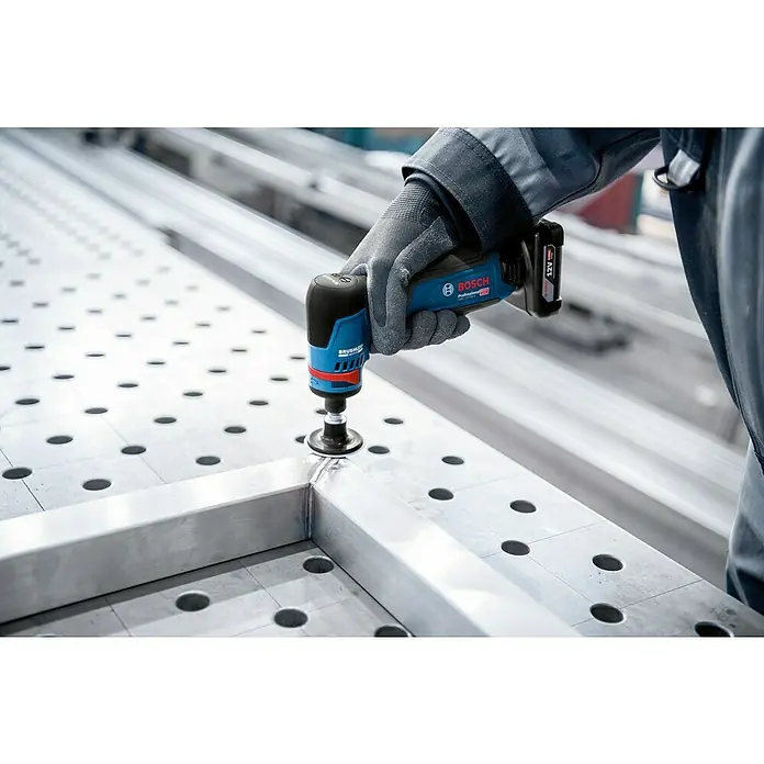 Bosch Professional Geradschleifer GWG 12V-50 S PRO SOLO - Leerlaufdrehzahl: 5.000 U/min - 15.000 U/min - Behandschuhte Hand glättet mit blau-schwarzem Bosch Akku-Werkzeug eine Metallschweißnaht an einem Aluminiumprofil auf einer Werkbank.
