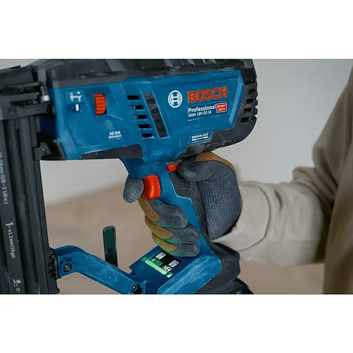 Bosch Professional Akku-Nagler GNH 18V-50 M PRO SOLO - 18 V, Ohne Akku, Länge Nagel: 16 mm - 50 mm - Eine behandschuhte Hand hält ein blau-schwarzes Bosch GNH 18V-50 M Akku-Nagelgerät, einsatzbereit.