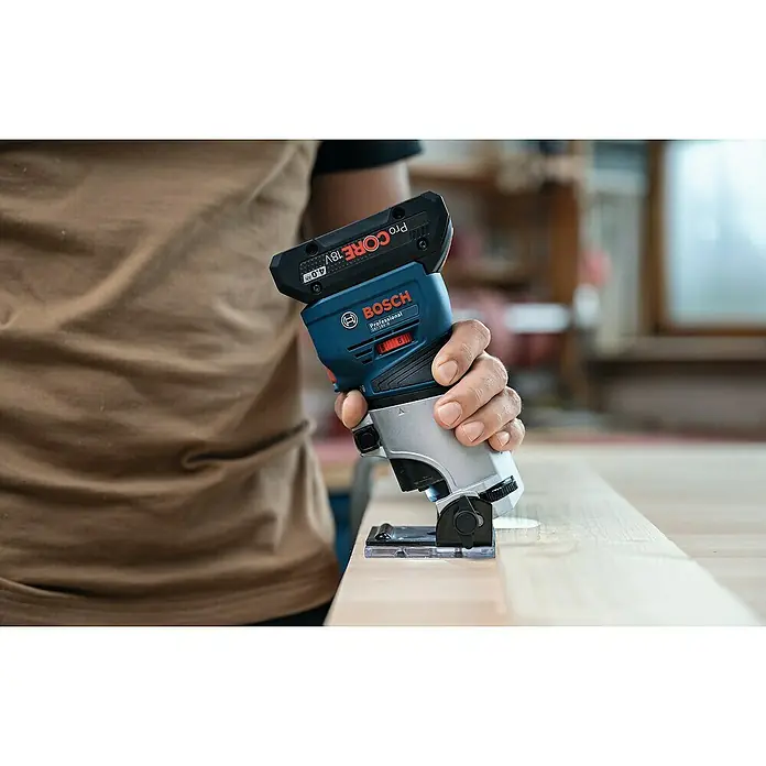 Bosch Professional AMPShare 18V Akku-Kantenfräser GKF 18V-8 PRO SOLO - 18 V, Ohne Akku, Leerlaufdrehzahl: 10.000 U/min - 30.000 U/min - Blau-silberner Bosch Professional Akku-Oberfräse mit schwarzem 18V 4.0Ah Akku, von einer Hand auf hellem Holz geführt.