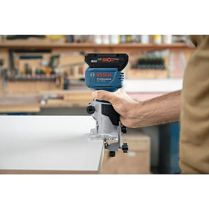 Bosch Professional AMPShare 18V Akku-Kantenfräser GLF 18V-8 PRO SOLO - 18 V, Ohne Akku, 10.000 U/min - 30.000 U/min, Inkl. L-Boxx - Eine Hand hält einen blau-schwarzen Bosch Professional GLF 18V-8 Fräser mit 18V ProCORE Akku, der die Kante einer weißen Platte bearbeitet.