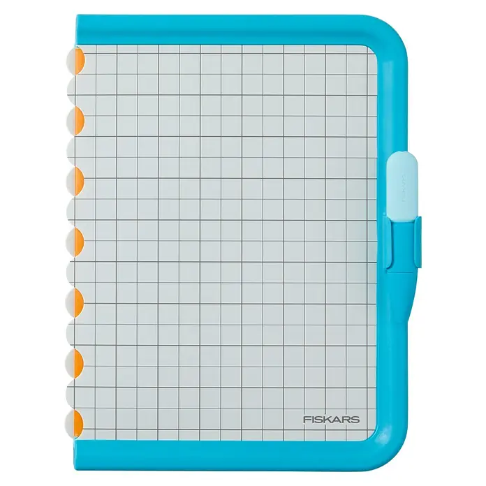 Fiskars Bastel-Set Schneidestift und -matte für Kinder - 2 -tlg. - Türkiser Kunststoff-Papierschneider mit weißer Gitter-Schneidematte und orangefarbenen Papierführungen.