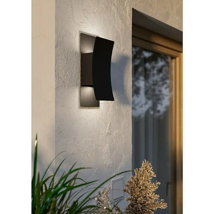 Eglo Aplique LED Verdolino - 8 W, An x Al: 120 x 280 mm, IP44, Negro - Moderno aplique de pared exterior negro curvo que emite luz cálida hacia arriba y hacia abajo en una fachada texturizada.