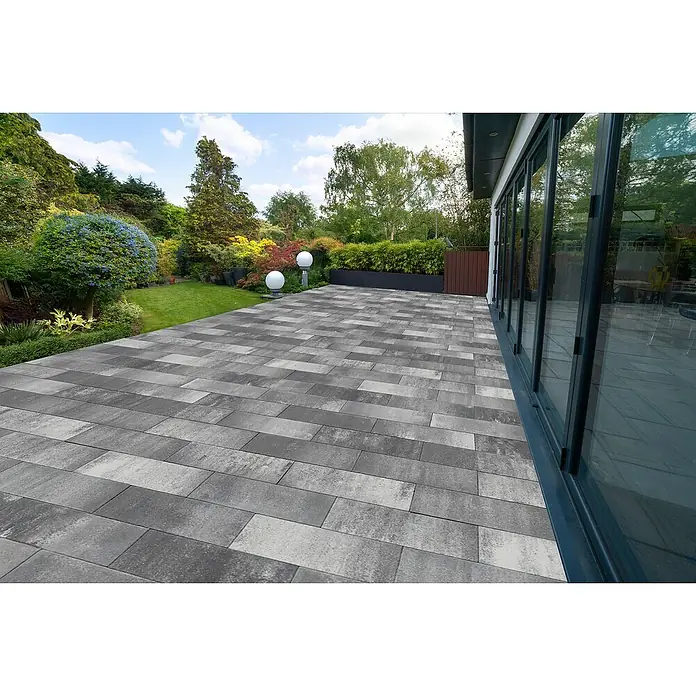 EHL EIBA Terrassenplatte - 60 x 26,6 x 5 cm, Grau-Anthrazit, Beton - Moderne Gartenpflasterung aus rechteckigen grauen Pflastersteinen mit variierenden Hell- und Dunkeltönen neben einem Haus.