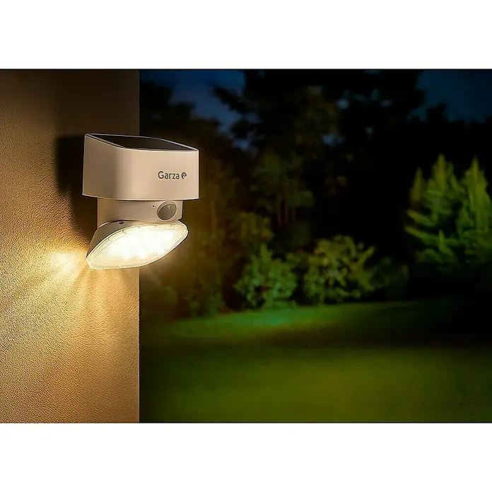 Garza Aplique solar LED para exterior - L x An x Al: 107 x 107 x 150 mm, Blanco, 2.000 lm, 3.000 K - 4.000 K, IP44 - Luz solar exterior blanca Garza montada en una pared texturizada, iluminando intensamente el área de noche.