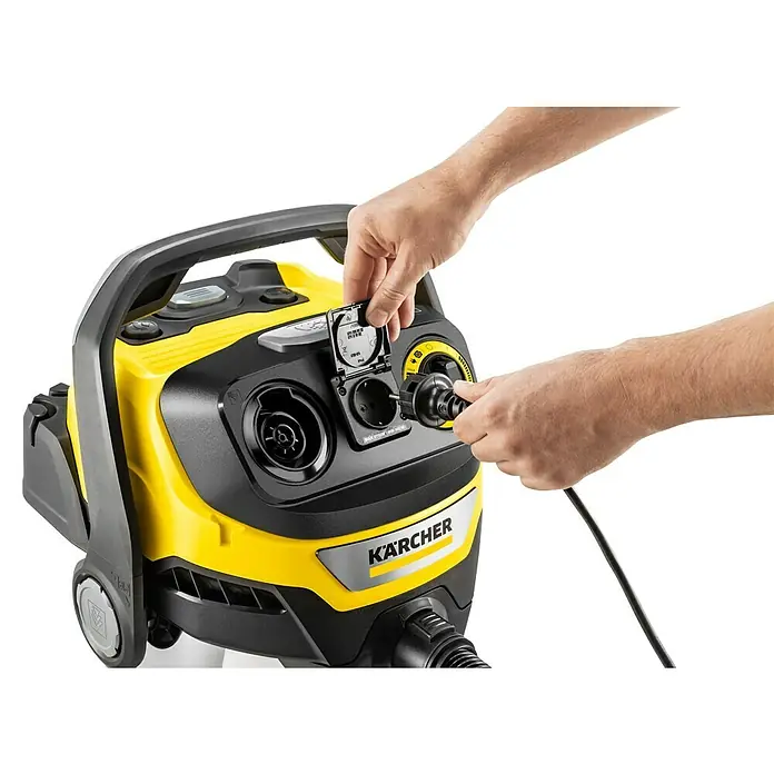 Kärcher Elektro-Nass- & Trockensauger WD 7 Control P S 30/6/35/T - Behältervolumen: 30 l, 1.400 W - Person steckt Netzkabel in integrierte Steckdose eines gelb-schwarzen Kärcher Industriestaubsaugers.