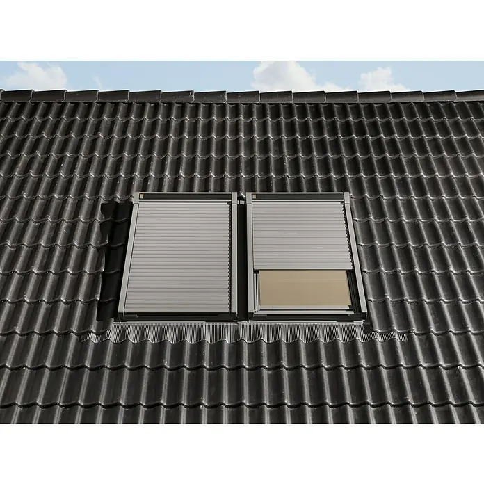 Velux Dachfenster-Rollladen Elektro SML CK06 0000K - Passend für Fenstergröße: CK06, C06, Passend für Fenstertyp: GGL, GGU, GPL, GPU, GHL, GHU, GZL, GLL, GLU, VU und VKU - Zwei graue Dachfenster mit Rollläden, eines geschlossen, eines teilweise offen, in einem dunklen Ziegeldach.