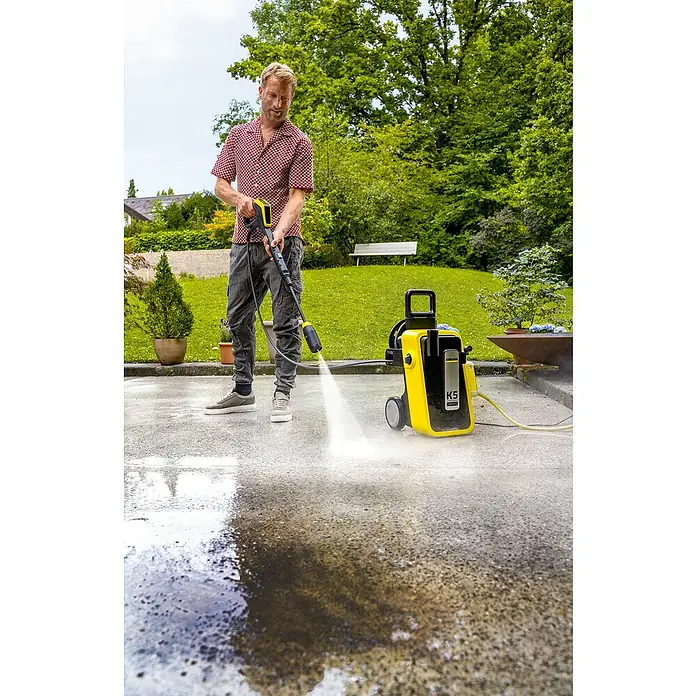 Kärcher Strahlrohr MJ 180 4-in-1 Multi Jet - Passend für: Kärcher Hochdruckreiniger K 6 bis K 7 - Mann reinigt Auffahrt mit gelb-schwarzem Kärcher K5 Hochdruckreiniger, Wasser spritzt.
