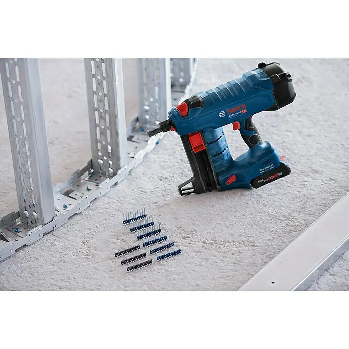 Bosch Professional Streifennägel NB-19 PRO - Länge Nagel: 19 mm, Verzinkt, 1.000 Stk. - Blauer und schwarzer Bosch Akku-Nagler neben Metallrahmen und Nagelstreifen auf Betonboden.