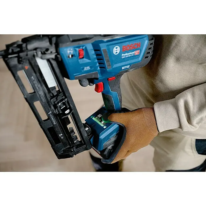 Bosch Professional Akku-Nagler GNH 18V-64-2 M PRO SOLO - 18 V, Ohne Akku, Länge Nagel: 32 mm - 64 mm - Blauer Bosch Akku-Nagler, von einer behandschuhten Hand gehalten, zeigt Akku und Nagelmagazin.