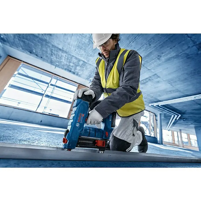 Bosch Professional Akku-Nagler GNB 18V-38 PRO SOLO - 18 V, Ohne Akku, Länge Nagel: 13 mm - 38 mm - Bauarbeiter nutzt blauen Bosch Professional Akku-Befestiger, um eine Metallschiene auf Betonboden zu fixieren.