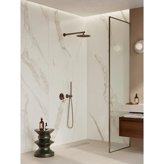Corso Italia Feinsteinzeugfliese Marble Calacatta - 120 x 278 cm, Weiß, Glänzend - Moderne begehbare Dusche mit weißen Marmorwänden, dunklen Bronze-Armaturen und einer Glasabtrennung in einem zeitgenössischen Badezimmer.