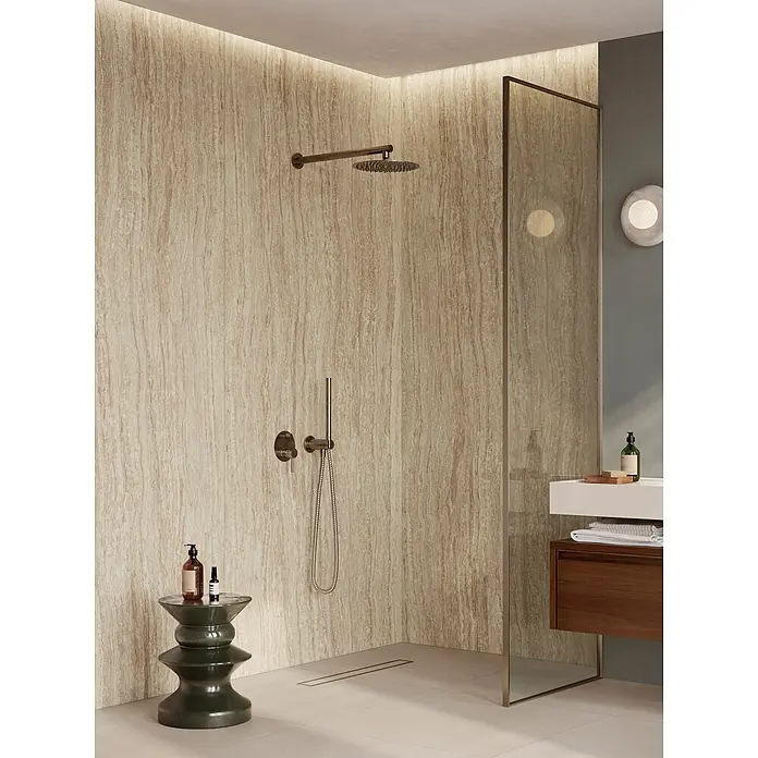 Corso Italia Feinsteinzeugfliese Traventino - 120 x 278 cm, Beige, Matt - Moderne Dusche mit hellbraunen Strukturwandpaneelen, bronzefarbener Kopf- und Handbrause sowie minimalistischer Glaswand.