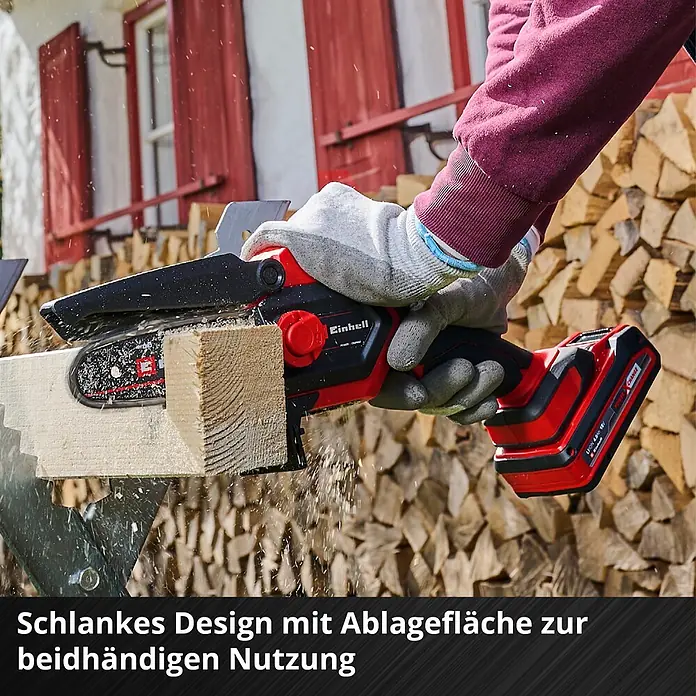 Einhell Power X-Change 18V Einhand-Akku-Kettensäge GE-PS 18/15 Li Holster Kit - 18 V, Li-Ionen, Ohne Akku, Schwertlänge: 15,8 cm - Rote und schwarze Einhell Akku-Mini-Kettensäge schneidet Holz, Späne fliegen. Von Hand in Arbeitshandschuh gehalten.