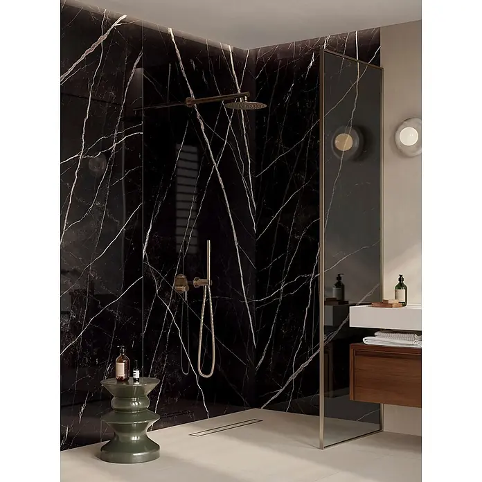 Corso Italia Feinsteinzeugfliese Calacatta - 120 x 278 cm, Schwarz, Glänzend - Schwarze Marmoroptik-Fliesen an eleganten Duschwänden, ergänzt durch goldene Armaturen in einem modernen Bad.