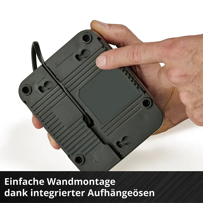 Einhell Power X-Change 18V Akku & Ladegerät Starter-Kit - 18 V, 1 Akku, 5,2 Ah - Dunkelgraue Geräterückseite, von Hand gehalten, zeigt integrierte Schlüssellochschlitze und Kabelführung zur Wandmontage.