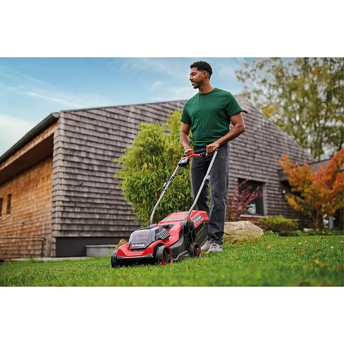 Einhell Power X-Change 18V Akku-Rasenmäher GE-CM 18/30-1 Li BL - 18 V, Ohne Akku, Schnittbreite: 30 cm - Ein Mann mäht einen Rasen mit einem roten und schwarzen Einhell Akku-Rasenmäher in einem Garten.