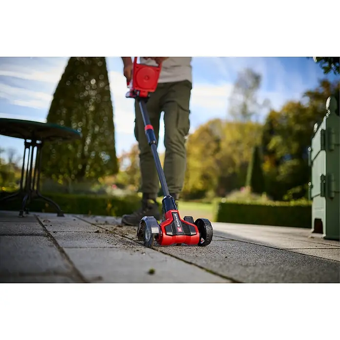 Einhell Power X-Change 18V Akku-Fugenreiniger GE-CC 18/110 Li E - 18 V - Einhell Rot-Schwarz Fugenreiniger, von Person auf Pflastersteinen im Garten genutzt.