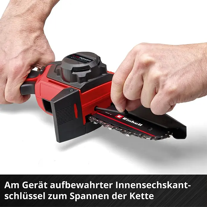 Einhell Power X-Change 18V Einhand-Akku-Kettensäge GE-PS 18/15 Li Holster Kit - 18 V, Li-Ionen, Ohne Akku, Schwertlänge: 15,8 cm - Eine Hand spannt die Kette einer rot-schwarzen Mini-Kettensäge mit dem am Gerät aufbewahrten Innensechskantschlüssel.