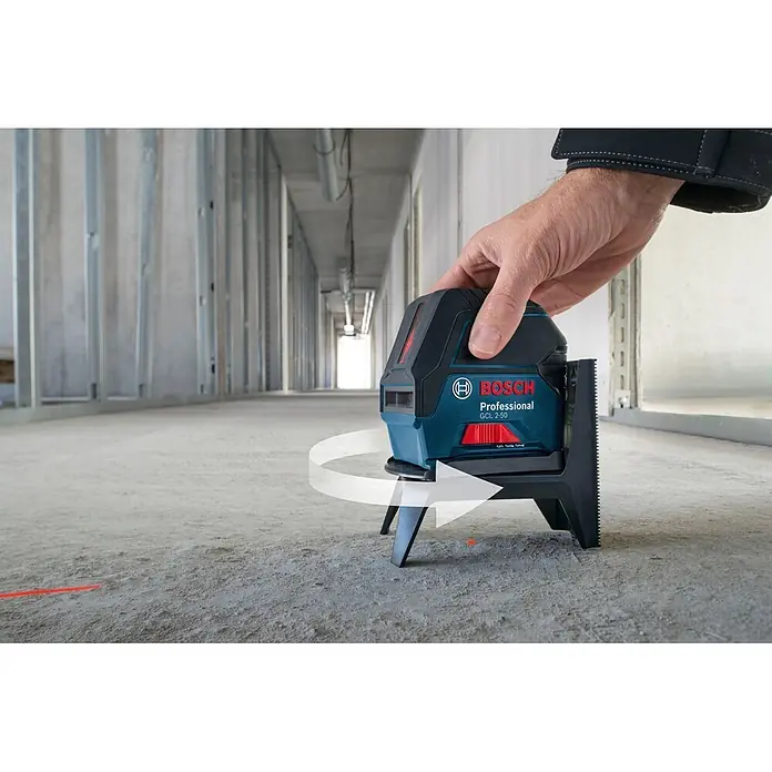 Bosch Professional Kombilaser GCL 2-50+LR6 PRO - Max. Arbeitsbereich mit Empfänger: 50 m - Blauer und schwarzer Bosch GCL 2-50 Professional Kreuzlinienlaser, von einer Hand gehalten und auf Baustellenboden drehend, projiziert rote Laserlinie.