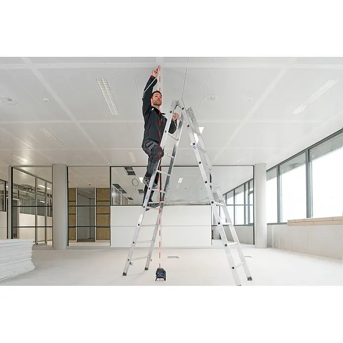 Bosch Professional Kombilaser GCL 2-50+LR6 PRO - Max. Arbeitsbereich mit Empfänger: 50 m - Mann auf Leiter nutzt blau-schwarzes Laser-Nivelliergerät, um eine vertikale rote Linie an die Decke zu projizieren.