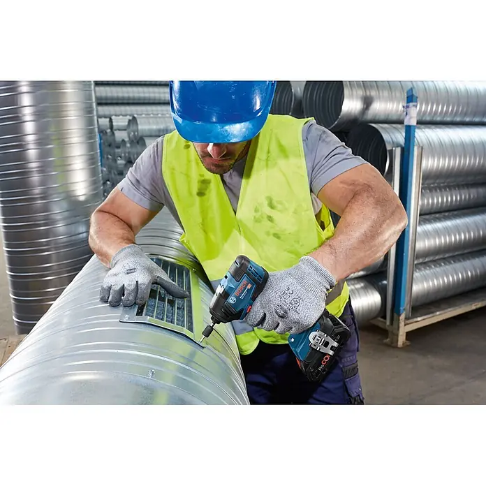 Bosch Professional AMPShare 18V Akku-Drehschlagschrauber GDR 18V-200 - 18 V, Ohne Akku, 200 Nm, Karton - Mann in Schutzkleidung befestigt mit einem Bosch Schlagschrauber ein Metallgitter an einem Lüftungsrohr.