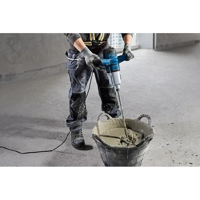 Bosch Professional Rührwerk GRW 140 - 1.400 W - Eine Person verwendet einen blauen und silbernen Bosch Profi Farb- und Mörtelrührer, um Mörtel in einem schwarzen Eimer zu mischen.