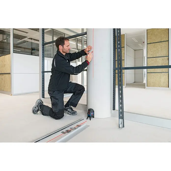 Bosch Professional Kombilaser GCL 2-50+LR6 PRO - Max. Arbeitsbereich mit Empfänger: 50 m - Mann nutzt blaues Bosch-Laser-Nivelliergerät, um rote vertikale Linie auf Säule zu projizieren und zu markieren.