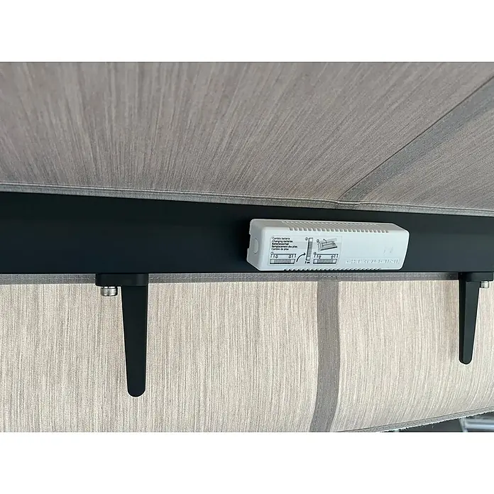 Spettmann Windsensor - 140 x 38 x 26 mm, Passend für: Spettmann offene Gelenkarm-, Halbkassetten- und Vollkassettenmarkisen - Weißes Cherubini Steuergerät mit Batteriehinweisen, an schwarzer Markisenstange über hellgrauem Stoff.