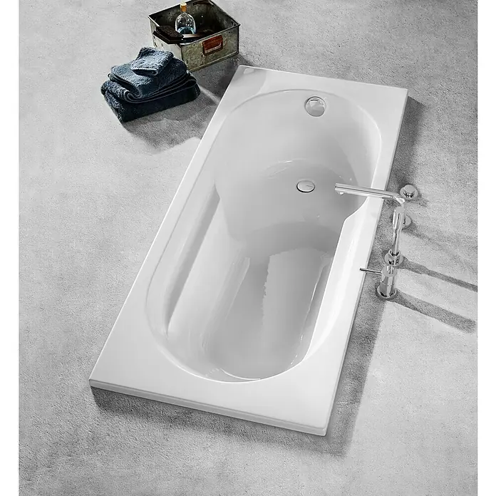 Camargue Brasilia Badewanne - 170 x 75 cm, Sanitäracryl, Weiß - Hochwinkelaufnahme einer rechteckigen, weißen Badewanne mit Armaturen, Handtüchern und Badutensilien auf einem grauen Betonboden.