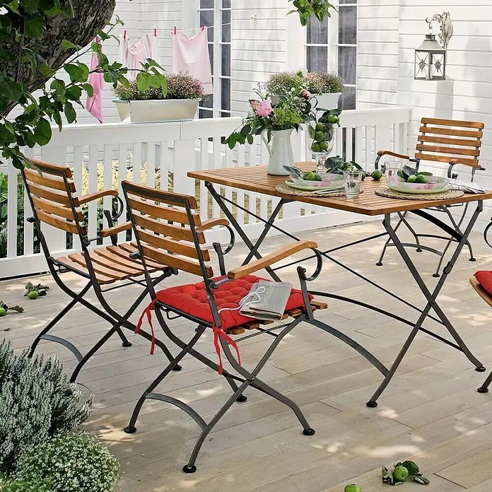 Sunfun Moni Gartenmöbel-Set I - 5 -tlg., Akazie, Stahl, Naturbraun/Schwarz - Elegantes Gartenset mit Holztisch und Stühlen mit roten Kissen auf einer sonnigen Terrasse, ideal für entspannte Stunden im Freien.
