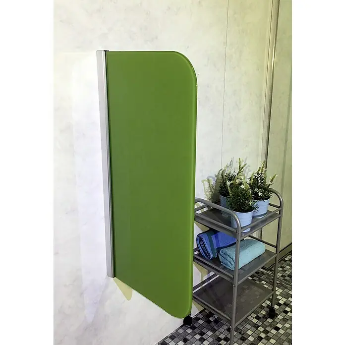 GEO Urinal-Trennwand Radius 100 - 50 x 90 cm, Glas, Grün - Ein grüner, beweglicher Raumteiler mit abgerundeter Ecke steht neben einem silbernen Servierwagen mit Handtüchern und Dekoration.