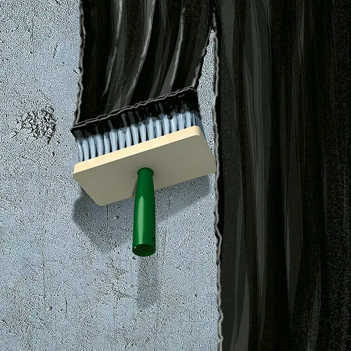 MEM Bitumen-Voranstrich - 1 l - Eine Malerbürste mit schwarzen Borsten und einem grünen Griff bedeckt eine graue Wand mit schwarzer Farbe.