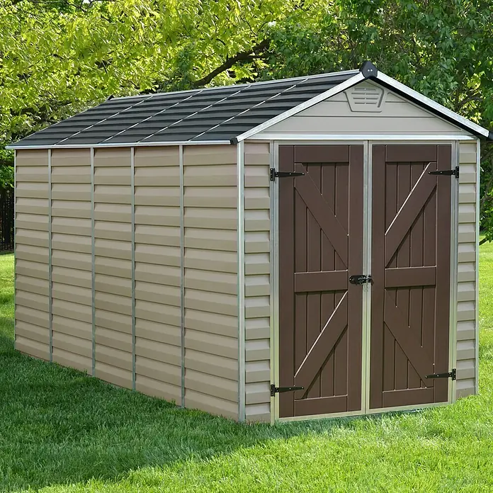 Palram – Canopia Gerätehaus Skylight 6x12 Tan - Außenmaß inkl. Dachüberstand (B x T): 185 x 379 cm, Kunststoff, Beige/Braun - Ein geräumiger Geräteschuppen mit Doppeltür und Satteldach, ideal für die Gartenaufbewahrung, steht auf einer grünen Rasenfläche.