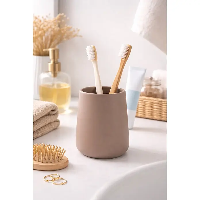 MSV Maonie Portacepillos - Ø x Al: 8,5 x 10 cm, Cerámica, Capuccino - Dos cepillos de dientes, uno blanco y otro de bambú, están en un soporte de cerámica beige sobre un mostrador de baño.