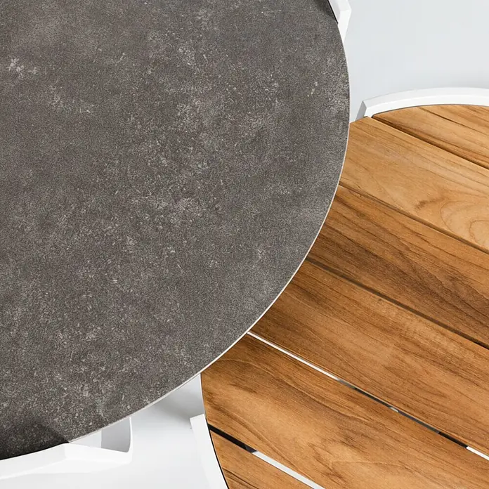 Kactus republic Conjunto de muebles Mónaco - 5 pzs., Aluminio/Teca, Blanco - Dos superficies de muebles de exterior parcialmente superpuestas: un tablero gris oscuro efecto piedra y una superficie de madera de lamas marrón cálido.
