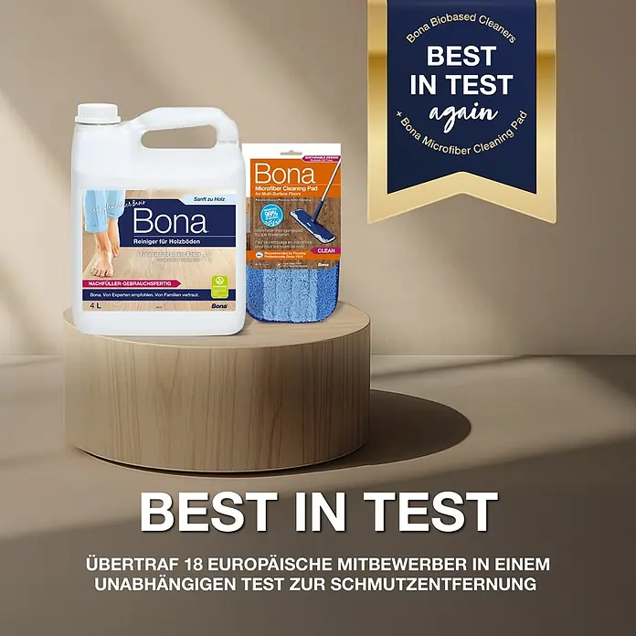 Bona Parkettreiniger - 4 l, Nachfüllkanister - Bona 4L Holzbodenreinigerflasche und ein blaues Mikrofaser-Reinigungspad auf einem hellen Holzständer mit 'Best in Test'-Banner.