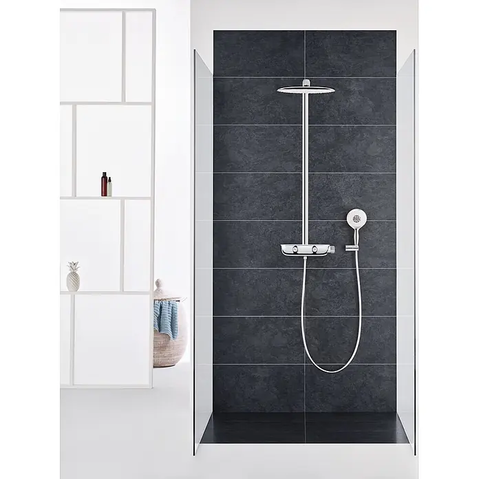 Grohe Rainshower SmartControl Sistema de ducha - Con grifería termostática, Distancia entre orificios: 100,6 cm, Número de tipos de chorro: 1 ud., Cromo, Moon White - Moderno sistema de ducha cromado con rociador, ducha de mano y mezclador termostático, instalado en una ducha con azulejos oscuros.