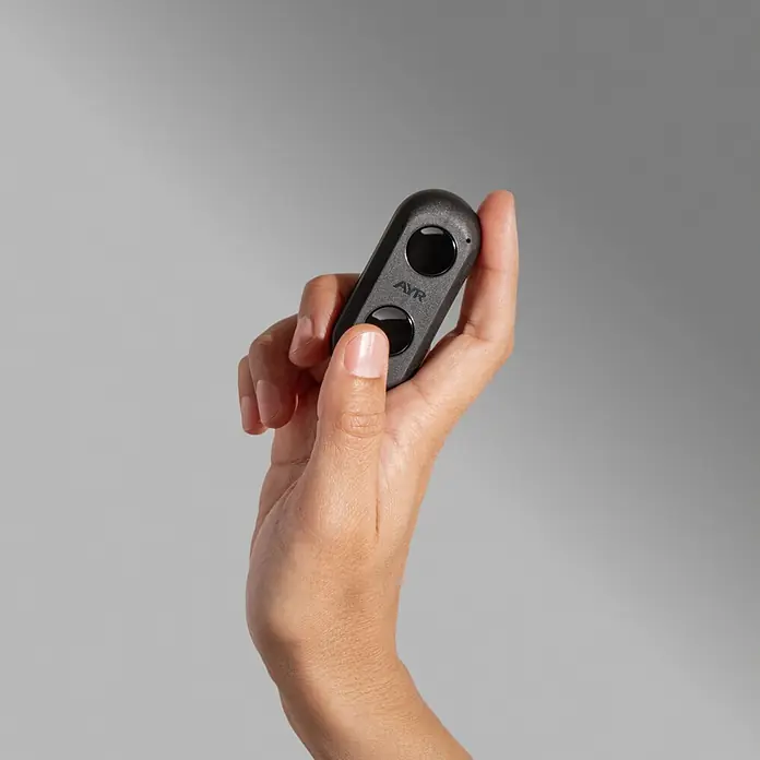 AYR Mando a distancia Key RF - Específico para: Cerraduras Lock RF de AYR, Negro - Mano sosteniendo un mando a distancia gris oscuro con dos botones negros y el logo AYR.