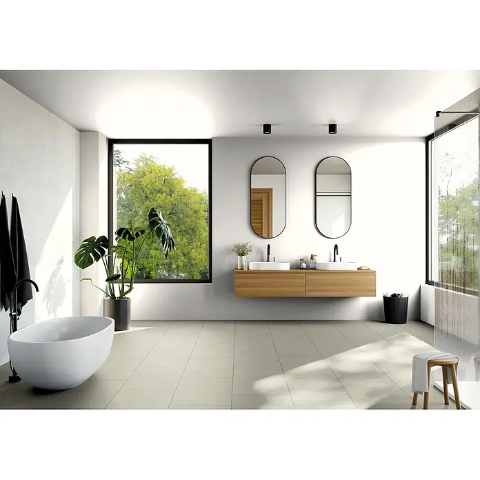 b!design Vinylboden SPC - Chiasso, Fliese, 800 x 400 x 5 mm - Modernes Badezimmer mit freistehender weißer Badewanne, doppeltem Holzwaschtisch mit schwarzen Armaturen und großen Fenstern mit Blick auf grüne Bäume.