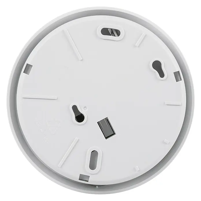 Homematic IP Alarmsirene HmIP-ASIR-2 - Batteriebetrieben, Alarmsignal: 90 dB, Ø x H: 12,4 x 4,5 cm - Die Unterseite eines runden, weißen Rauchmelders mit Befestigungslöchern und rechteckigen Schlitzen auf schwarzem Hintergrund.