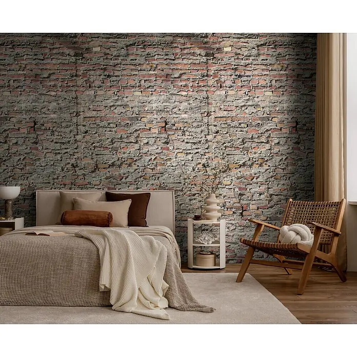 A.S. Création Metropolitan Stories Vibes & Styles Fototapete Mauer - B x H: 1,59 x 2,8 m, Vlies - Gemütliches Schlafzimmer mit neutralem Bett, einem Stuhl aus Holzgeflecht und Beistelltischen vor einer Ziegelwand.