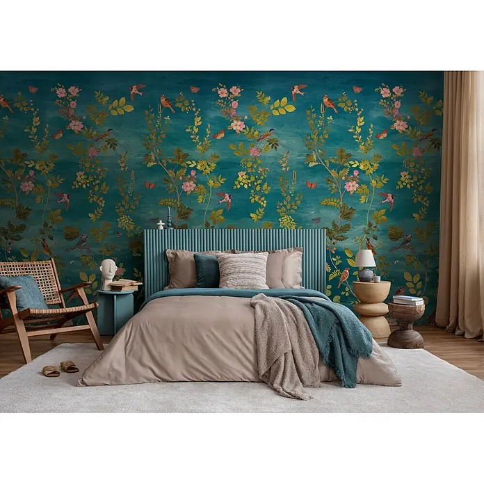 A.S. Création Metropolitan Stories Vibes & Styles Fototapete Blüte - B x H: 1,59 x 2,8 m, Vlies - Ein Schlafzimmer mit einem Bett mit beigem Bettbezug, blauem Überwurf, geripptem blauem Kopfteil, flankiert von Holznachttischen und floraler Tapete.